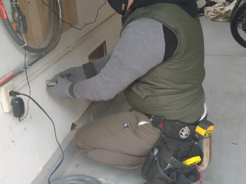Electrician performing outlet wiring in a Bono garage